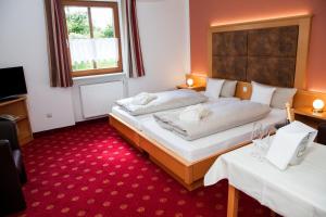 BlaibachにあるSchlossgasthof Röschの赤いカーペットフロアのベッドルーム1室(ベッド2台付)