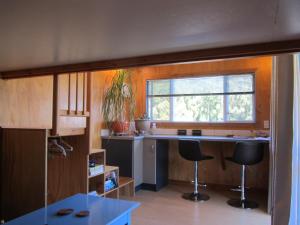 a kitchen with a counter and two stools in it at Snowberry Cottage at Lochsloy Farm Little River in Little River