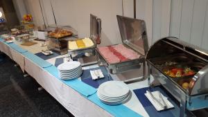 a buffet line with plates and food on a table at Water's Edge Hotel in Birżebbuġa