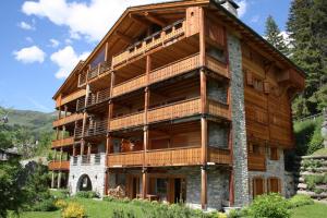 a large wooden building with balconies on it at Eclat de Soleil 023 in Verbier