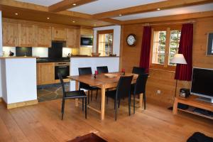 a kitchen and dining room with a wooden table and chairs at Eclat de Soleil 023 in Verbier