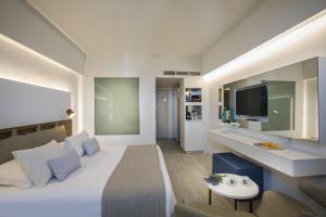 A bed or beds in a room at Lordos Beach Hotel & Spa