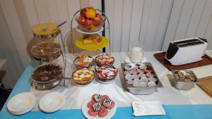 a table with a bunch of cupcakes and other desserts at Water's Edge Hotel in Birżebbuġa