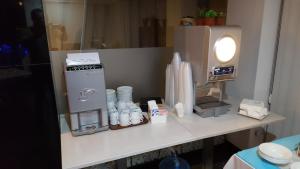 a counter top with a coffee maker and a coffeeaffle at Water's Edge Hotel in Birżebbuġa