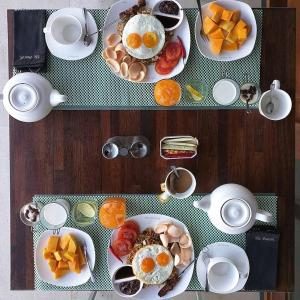 a table topped with plates of food with eggs and fruit at The Puncak Lombok in Senggigi