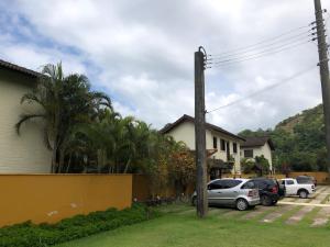 a house with two cars parked in a yard at Paúba · Paúba Beach House -Em lindo condomínio c/ piscina in São Sebastião