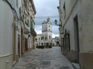 an empty street with a clock tower in the distance at Appartamento Caniglia in Francavilla Fontana