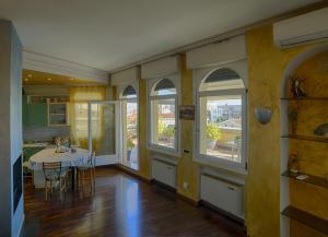 a dining room with a table and some windows at Holiday Treviso Attico Vittoria in Treviso