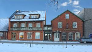 a large brick building on a street in the snow at Edgari Guesthouse in Otepää