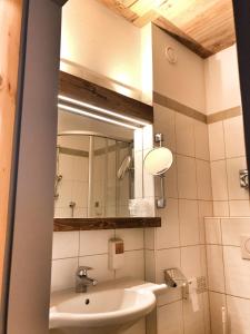 ein Bad mit einem Waschbecken und einem Spiegel in der Unterkunft Hotel Ansitz Haidenhof in Lienz