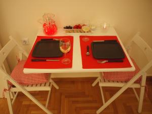 een rode en witte tafel met 2 stoelen en wijnglazen bij Charming Studio Posh Quartier (Kolonaki Athens) in Athene