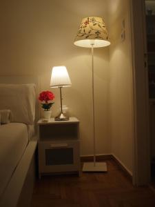een lamp op een nachtkastje naast een bed bij Charming Studio Posh Quartier (Kolonaki Athens) in Athene