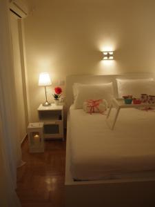 een slaapkamer met een wit bed met een boog erop bij Charming Studio Posh Quartier (Kolonaki Athens) in Athene