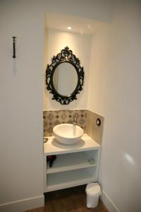 baño con lavabo y espejo en la pared en Les Loges de L'Atelier en Charlieu