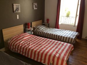 1 dormitorio con 2 camas y ventana en Le Petit Bijou en Saint-Fraigne