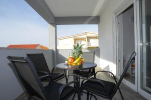 a table with a bowl of fruit on a balcony at Privilege Pool Apartments in Novalja