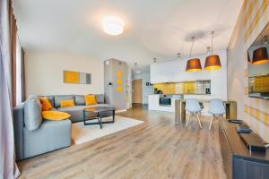 a living room with a couch and a table at Apartamenty Sun & Snow Sopocka Przystań in Sopot