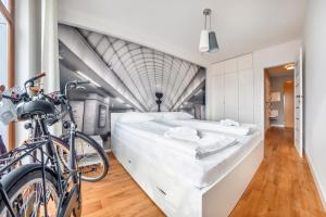 Una cama en una habitación con una bicicleta al lado en Apartamenty Sun & Snow Sopocka Przystań, en Sopot