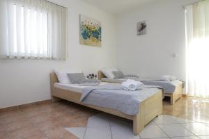 2 Betten in einem Zimmer mit weißen Wänden in der Unterkunft Lucky Luke Pool Apartments in Novalja
