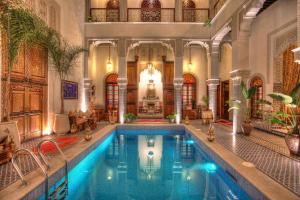an indoor swimming pool in a building with a large lobby at Riad El Amine Fès in Fez