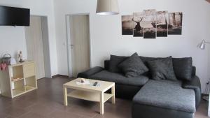 a living room with a couch and a table at Ferienwohnung Am Alten Forsthaus Neuenbau in Neuenbau