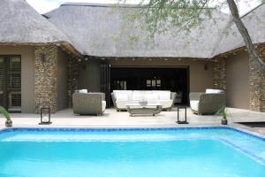 a swimming pool in front of a villa at Luvivane Luxury Villa in Marloth Park