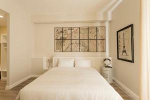 um quarto com uma cama branca e um mapa na parede em Livingstone B&B em Matera