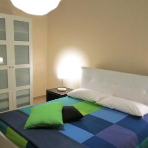 1 dormitorio con 1 cama con una manta colorida y una lámpara en B&B Prima Classe, en Belpasso