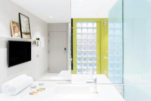 a bathroom with a sink and a tv and a mirror at Hotel Rec Barcelona - Adults Only in Barcelona