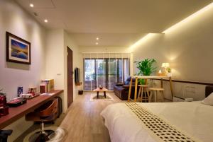 a bedroom with a bed and a living room at The Sunbeam Hideaway B&B in Luodong