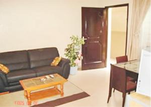 a living room with a black couch and a table at Résidences La Fourmi in Lomé