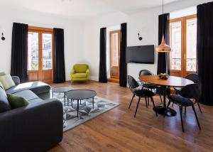 een woonkamer met een bank en een tafel en stoelen bij B&B Apartamentos Madrid Centro Fuencarral 46 in Madrid
