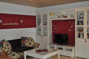 ein Wohnzimmer mit einem Sofa und einem TV in der Unterkunft Ferienwohnung Klatt-Gallus in Meißenheim