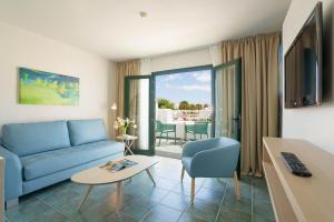 a living room with a blue couch and a table at Relaxia Lanzaplaya in Puerto del Carmen