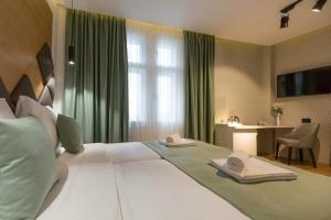 a hotel room with a large bed with towels on it at Capital Hotel Garni in Belgrade