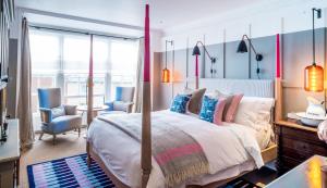 a bedroom with a bed and a table and chairs at The Swan Hotel in Southwold