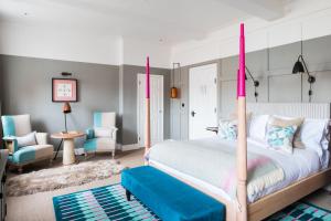 a bedroom with a bed with pink posts at The Swan Hotel in Southwold