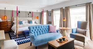 a bedroom with a bed and a blue couch at The Swan Hotel in Southwold