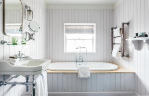 a bathroom with a tub and a sink at The Swan Hotel in Southwold