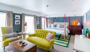 a bedroom with a bed and a yellow couch at The Swan Hotel in Southwold