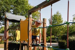a young boy riding on a playground at Camping Capfun La Bretèche in Les Épesses