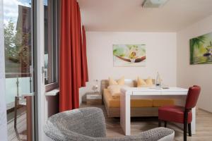 a living room with a white table and a couch at Hotel Nora in Bad Krozingen