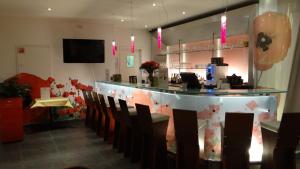 a restaurant with a bar with chairs and a counter at ibis Antwerpen Centrum in Antwerp
