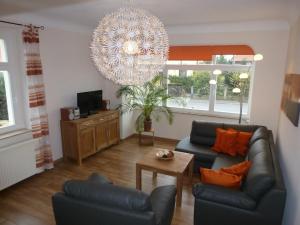 ein Wohnzimmer mit zwei Sofas und einem Kronleuchter in der Unterkunft Ferienwohnung Hohaus Dresden in Dresden
