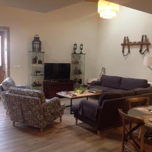 een woonkamer met een bank en een tafel en stoelen bij O Cruceiro in Boiro
