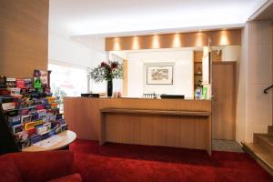 a lobby with a reception desk and a red carpet at Hotel Sachsenhof in Berlin
