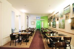 a dining room with tables and chairs and a green door at Hotel Sachsenhof in Berlin