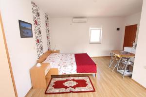 niewielka sypialnia z łóżkiem i stołem w obiekcie Apartments Sena w Rovinj