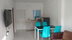 uma sala de jantar com uma mesa e cadeiras azuis em Apartamento en Taganga em Taganga