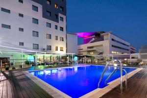a large swimming pool in front of a building at Hotel Sevilla Center in Seville